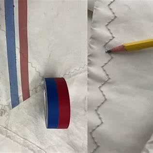 Close-up of UV-damaged stitching along a sail’s leech, showing fraying and fabric brittleness.