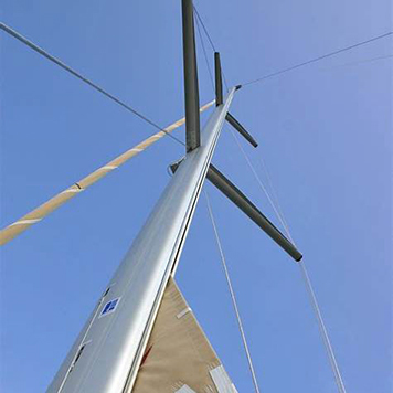 Close-up view of an in-mast furling system showing the mainsail furling vertically into the mast
